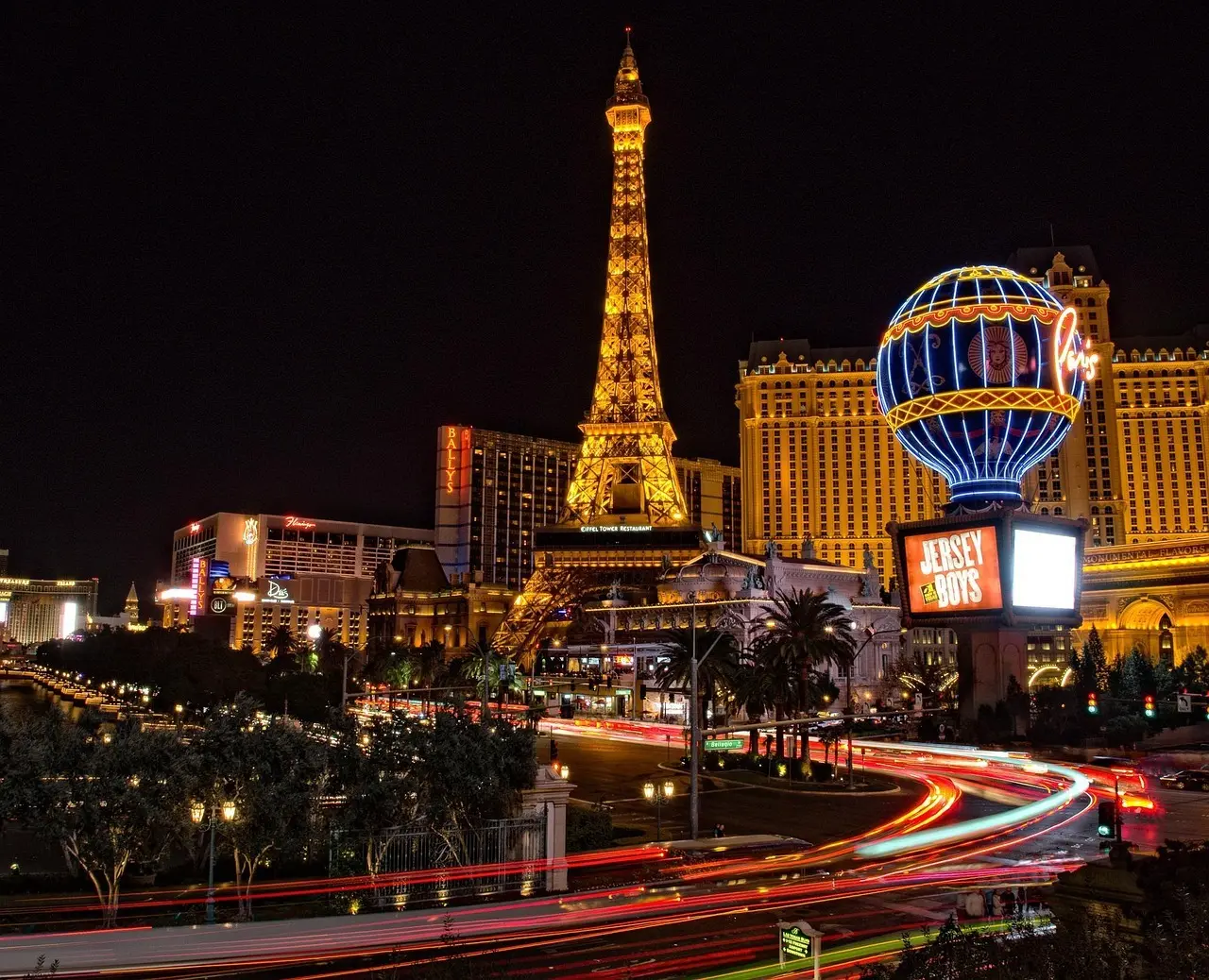 Las Vegas Strip om natten med opplyste kasinoer og en Eiffeltårn-replika