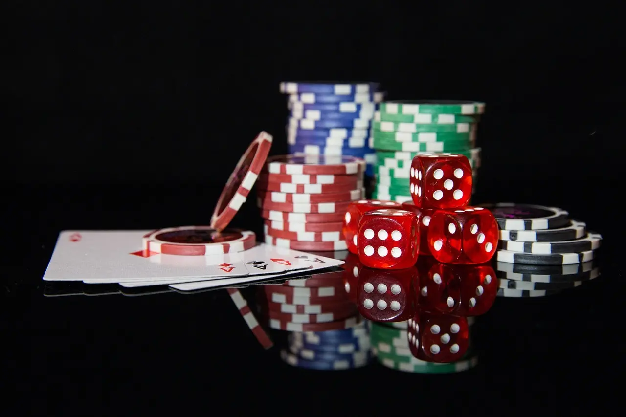 Pokerbrikker, røde terninger og spillekort på et bord